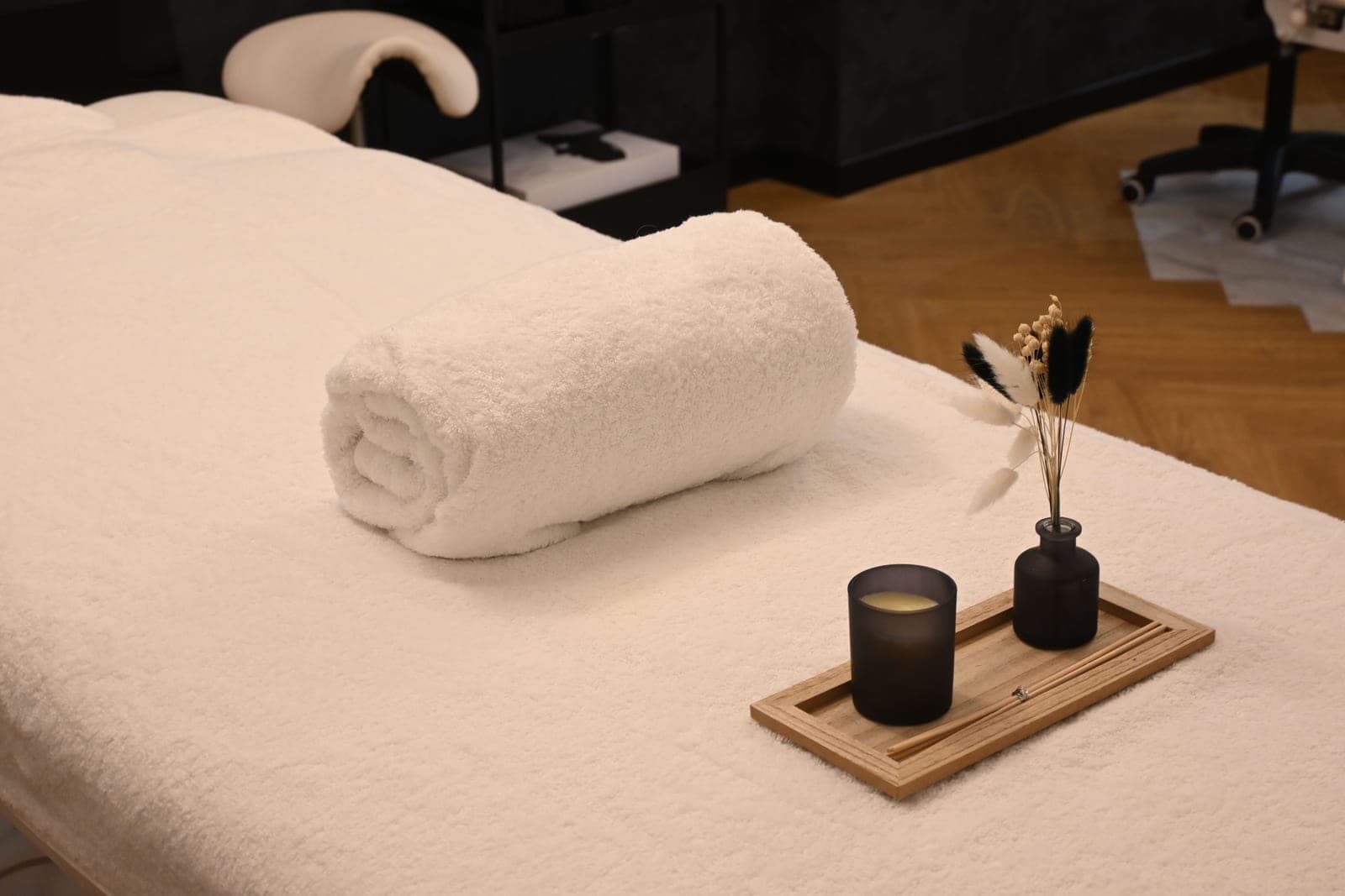 A serene treatment room set up with a rolled towel and candle.